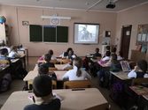 дети за партами смотрят фильм о блокаде Ленинграда
